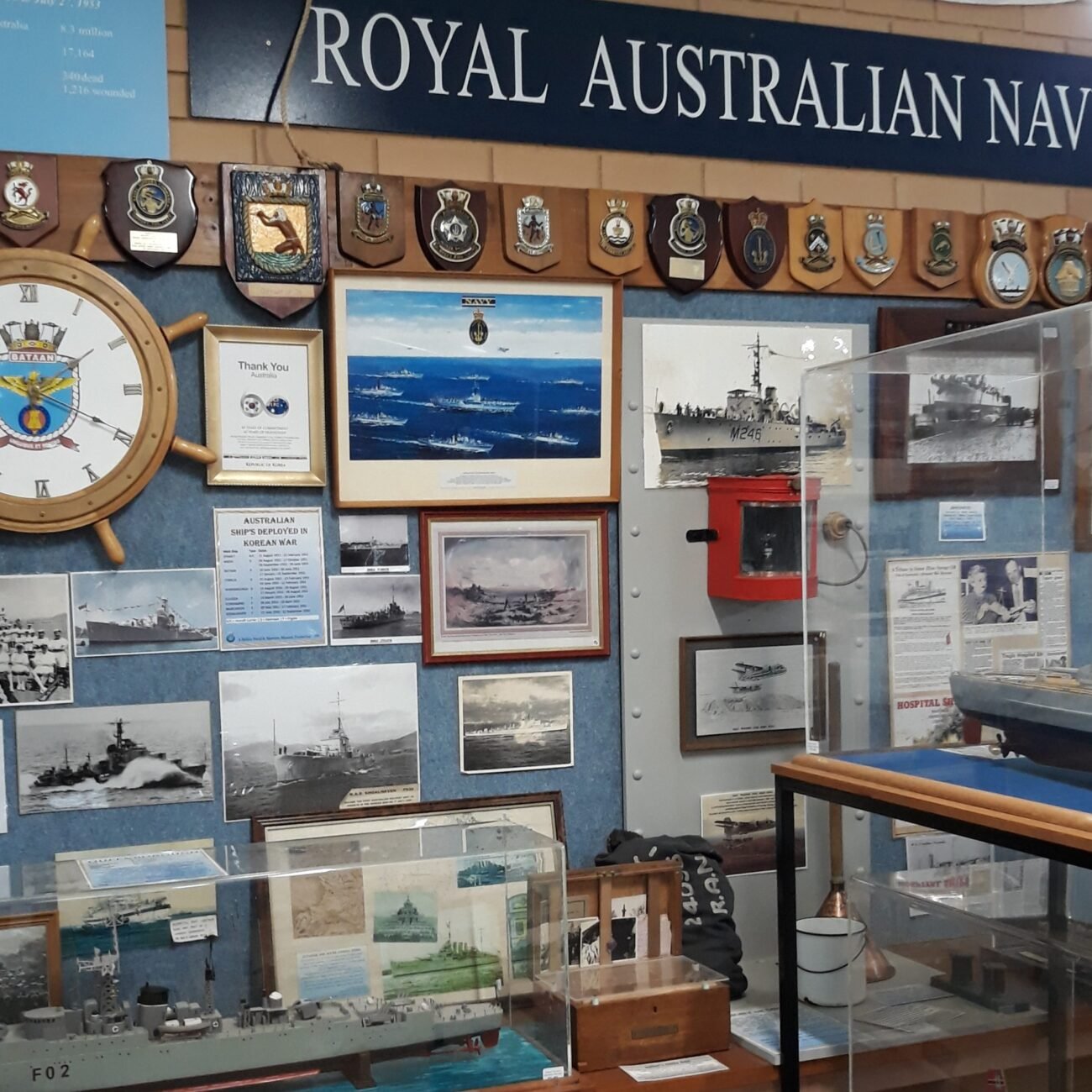 Royal Australian Navy display wall of ship badges and model ships inside the Ballina Naval and Maritime Museum